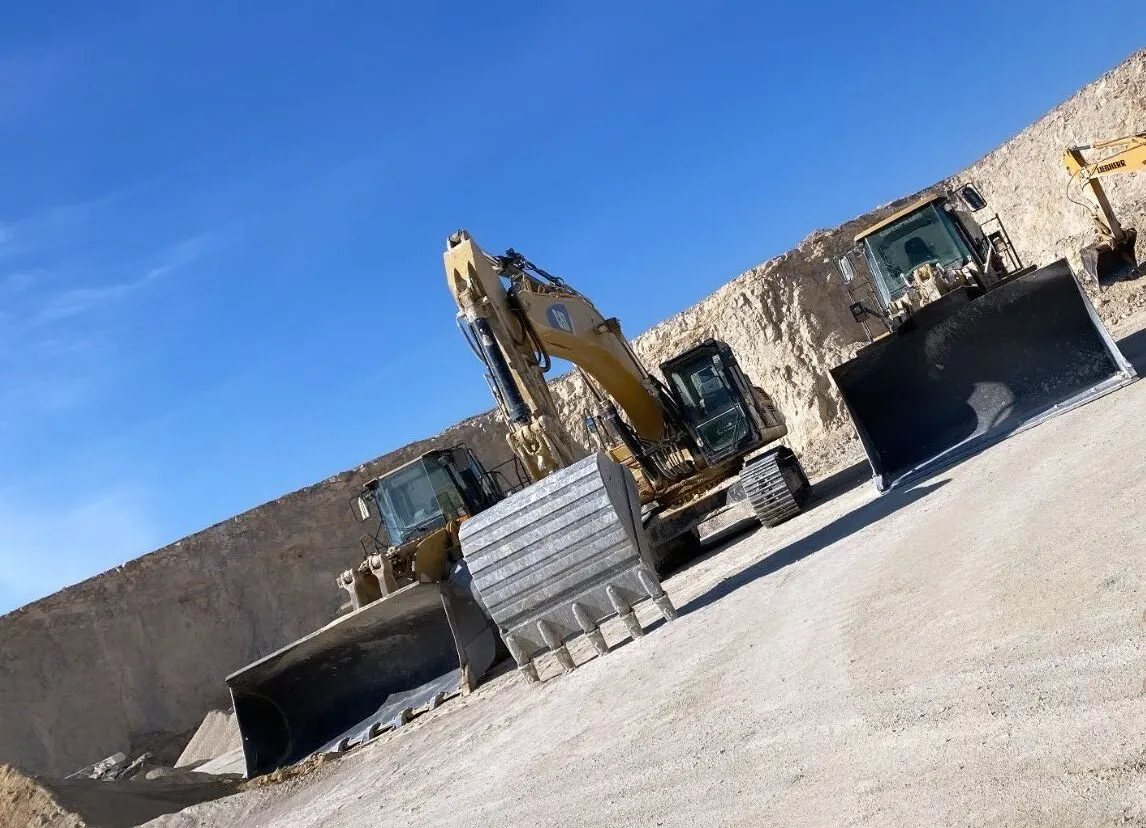 Excavadora y pala cargadora trabajando en una cantera