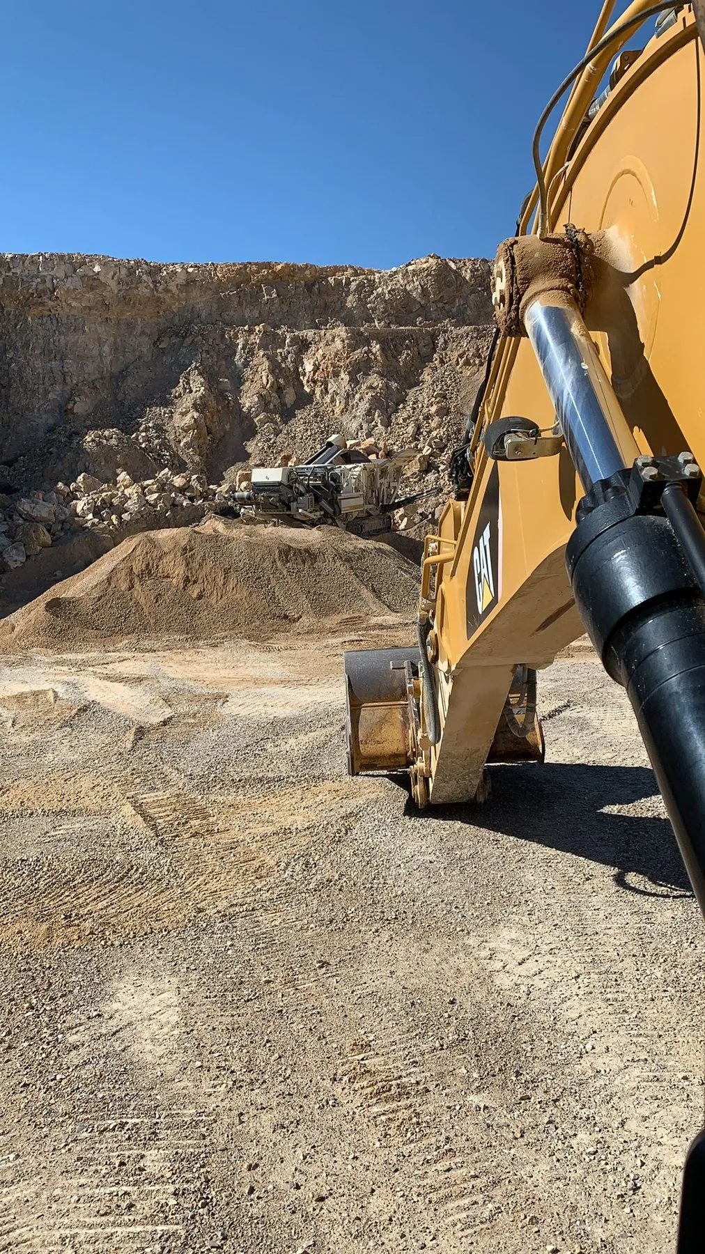 Excavadora junto a un acopio de grava